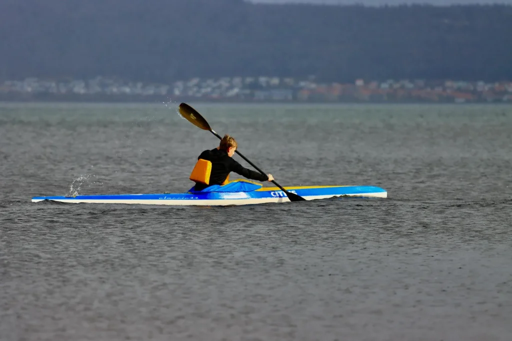 Kayaker paddling on open water with gear stored safely