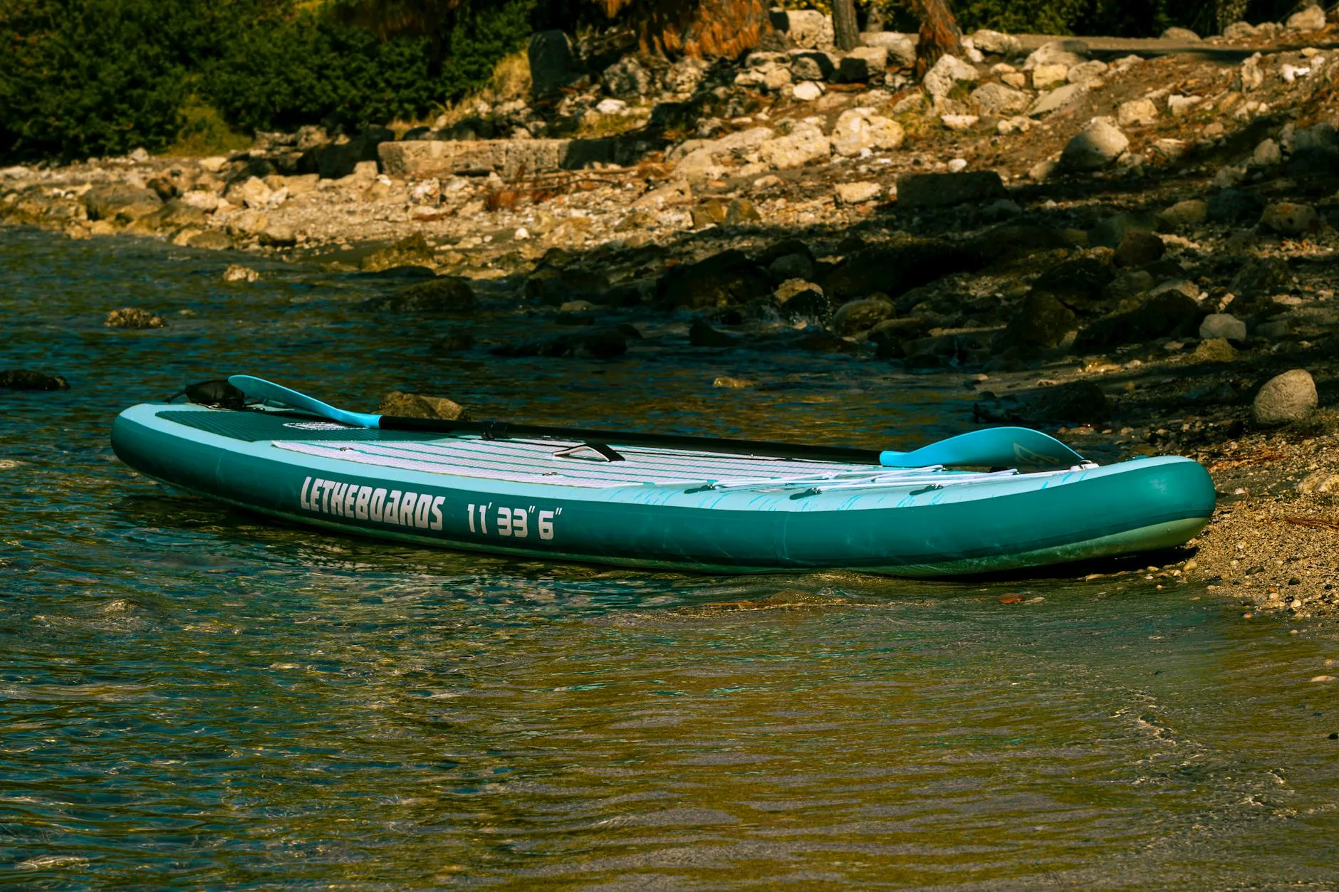 Inflatable paddleboard with pump and accessories on a beach