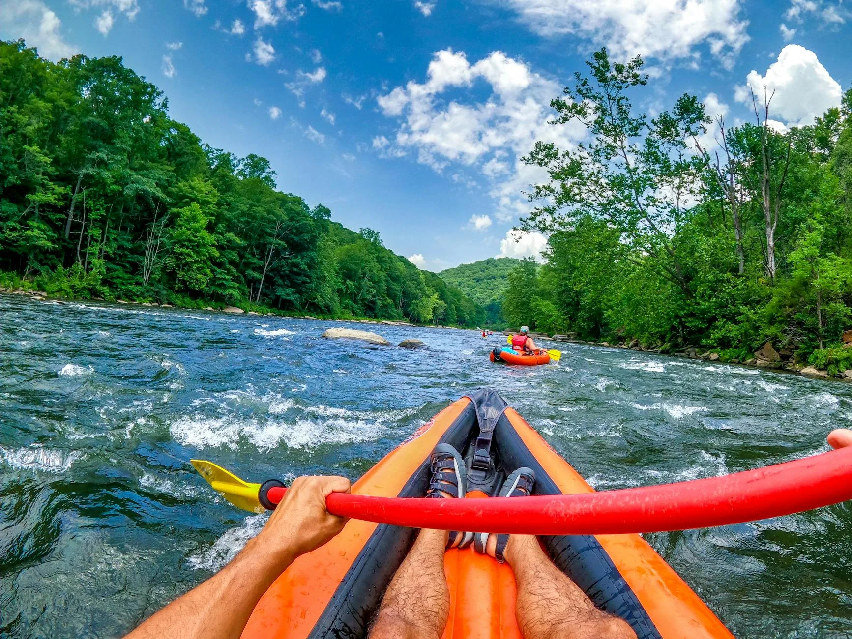 Close-up of a kayak paddle blade cutting through river water