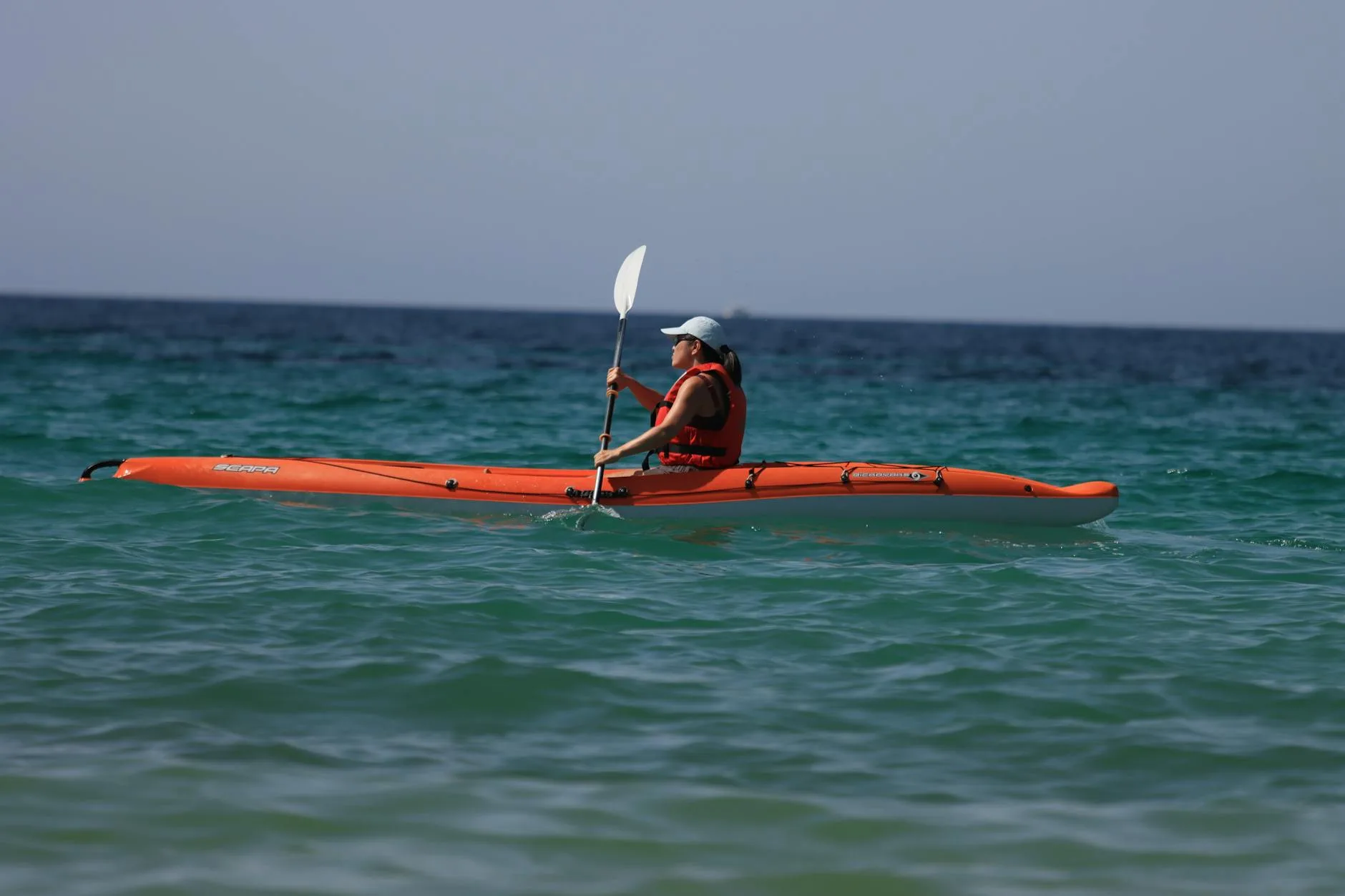 Kayaker paddling in windy coastal conditions