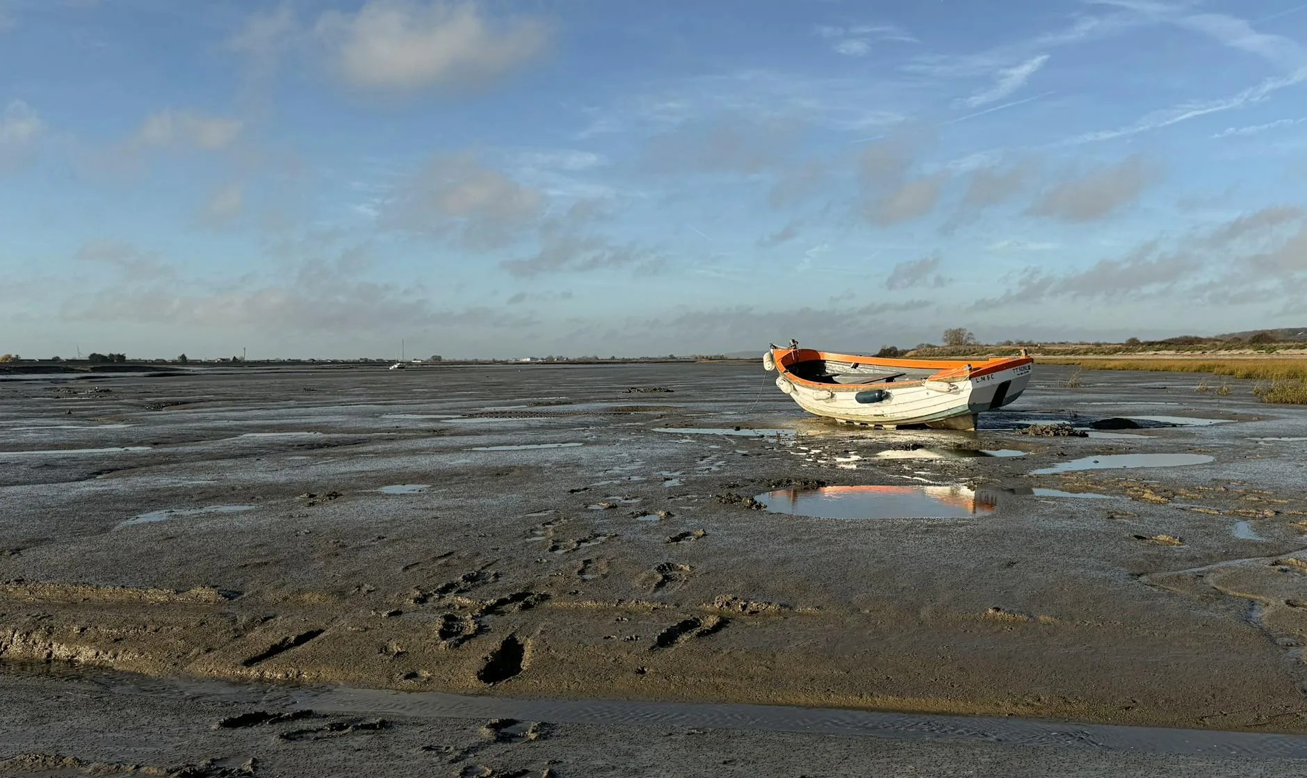 Boat stranded on exposed mudflats at low tide
