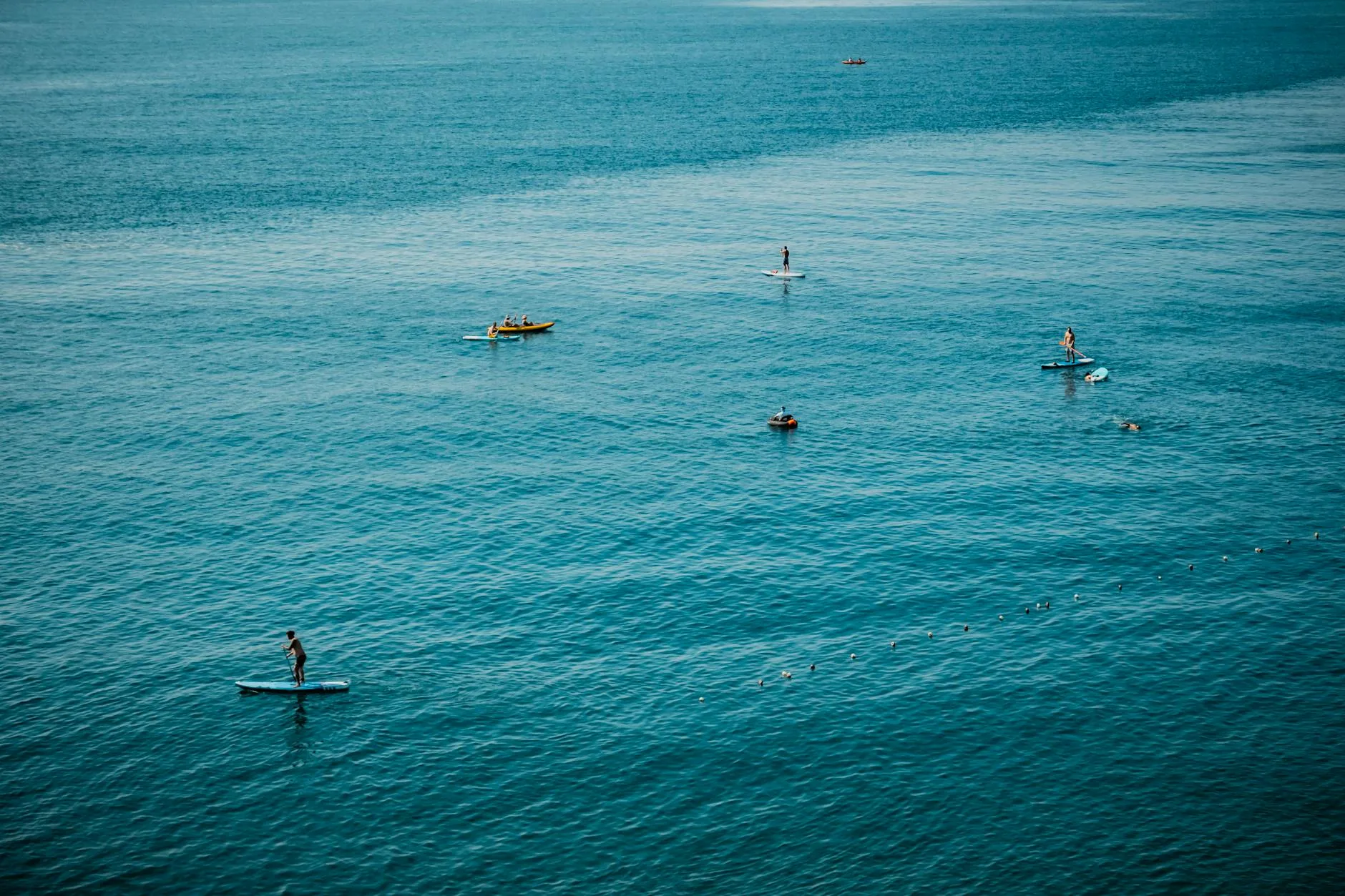 Paddleboard and equipment on a beach shore