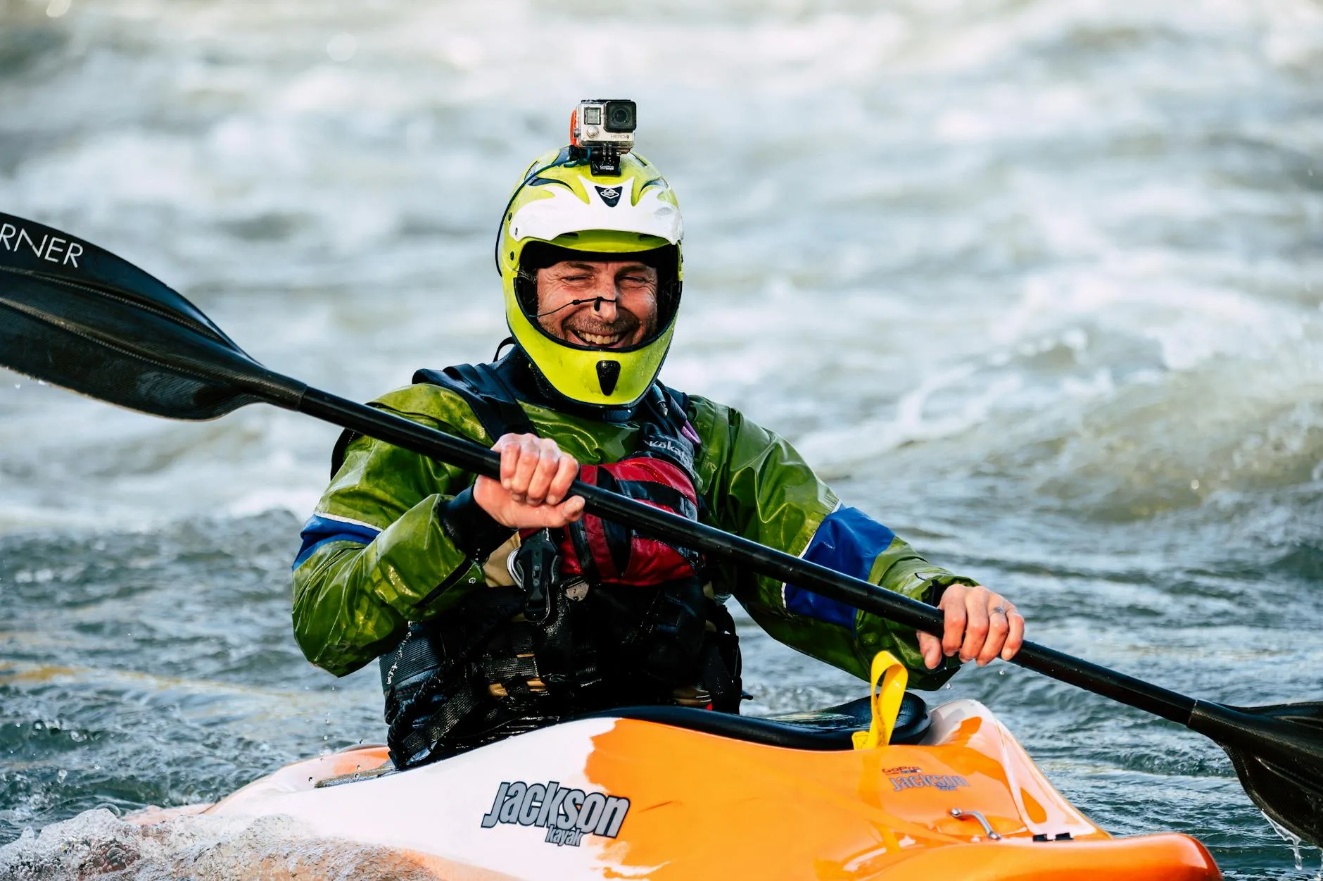 Kayaker in protective gear paddling in choppy cold water