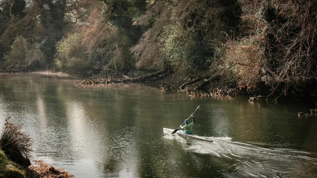 Kayaker paddling on a cold river in winter conditions