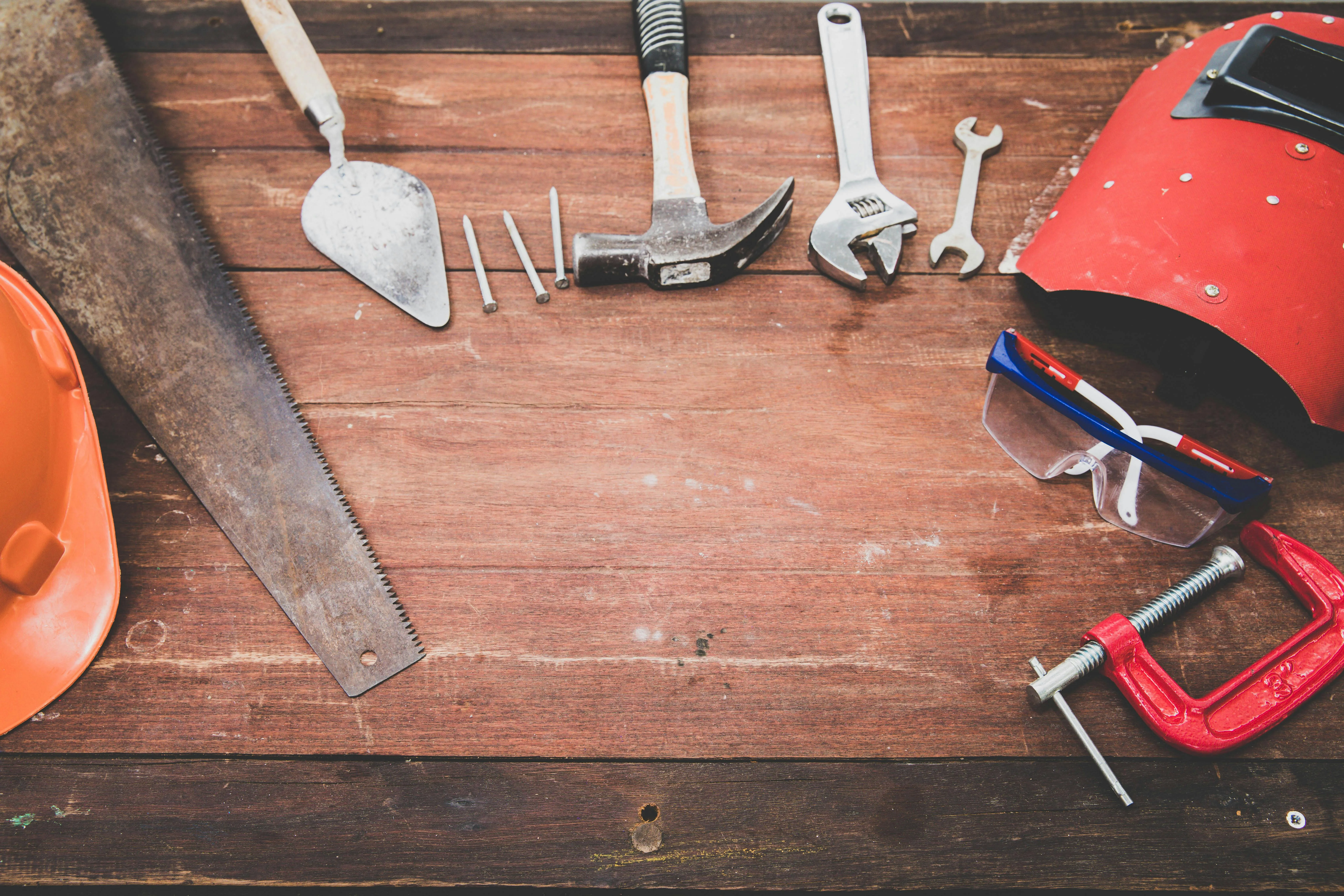 Repair tools including clamps and a saw laid out on a workbench