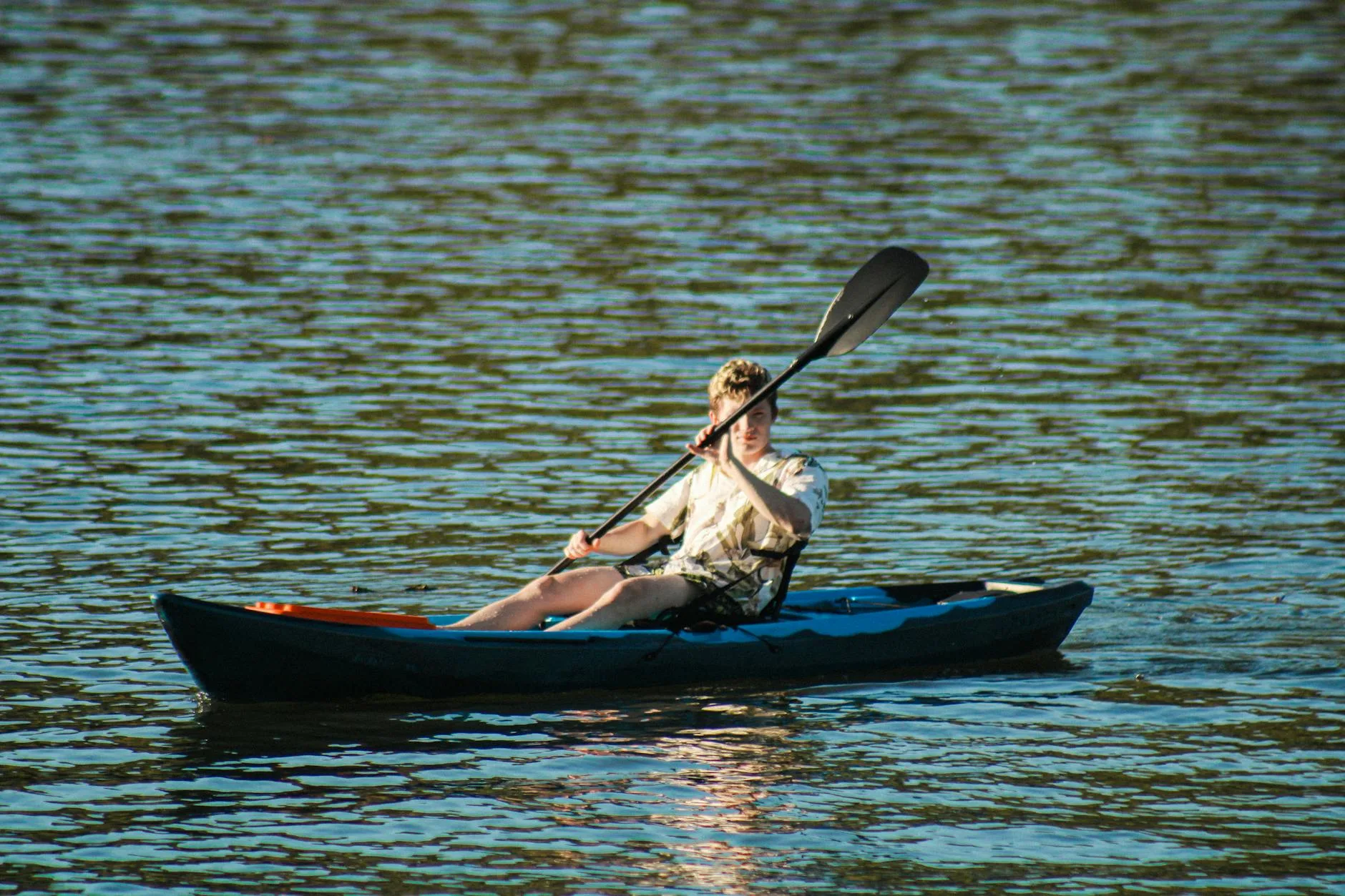 Solo kayaker on a scenic river in the countryside