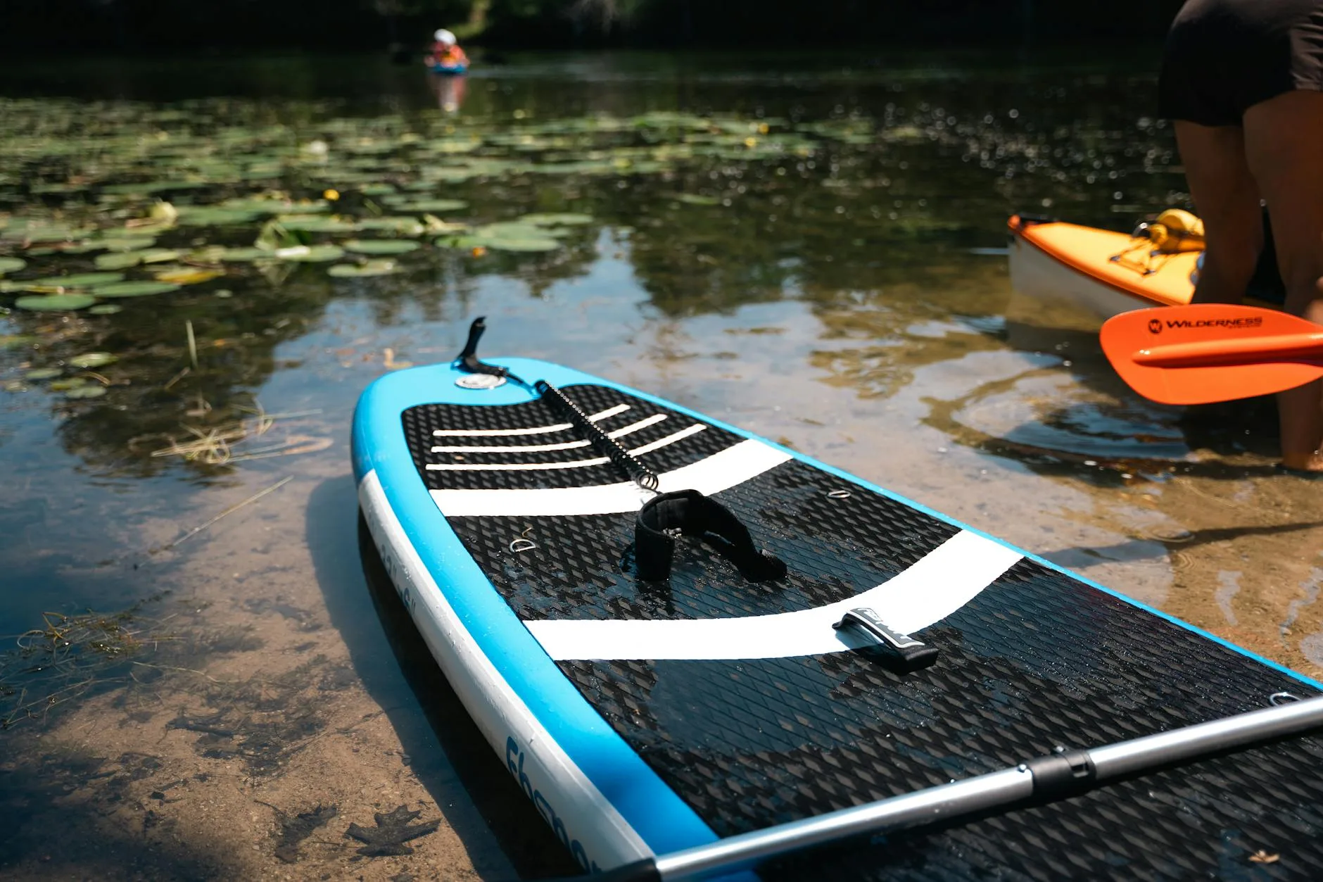 Stand up paddleboard accessories and gear laid out before a session
