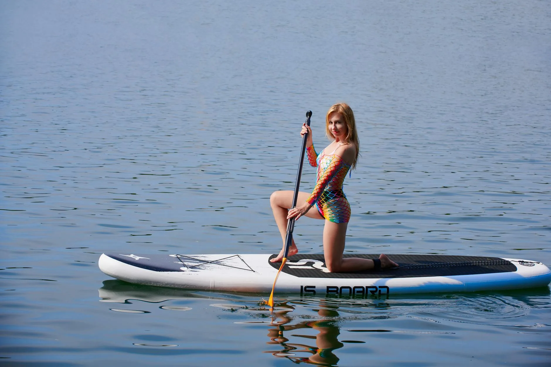 Paddleboarder kneeling on SUP for balance in rough water