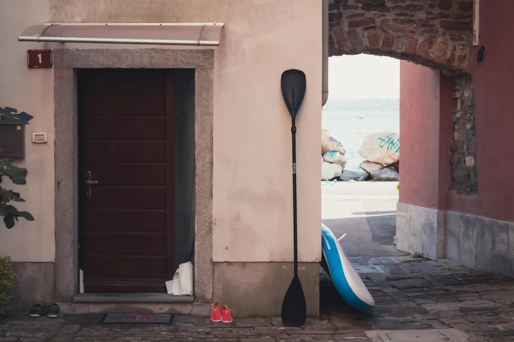 SUP paddle and equipment packed for travel on a sandy beach