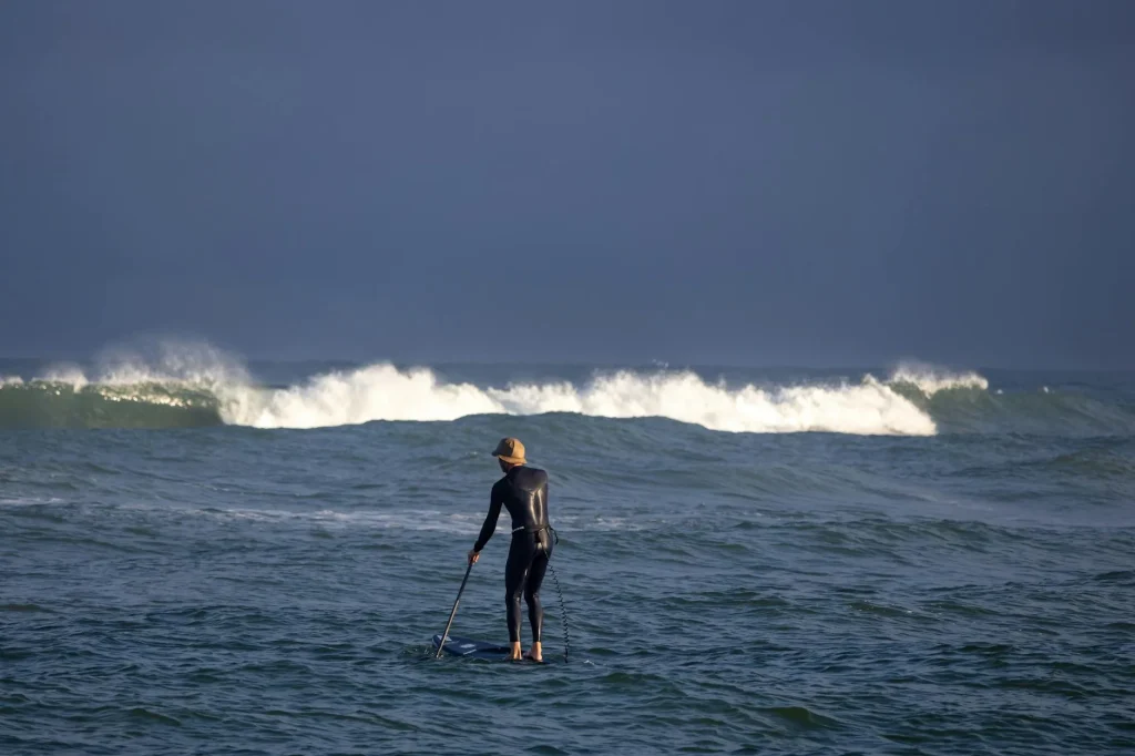 Stand up paddleboarder paddling in windy choppy water