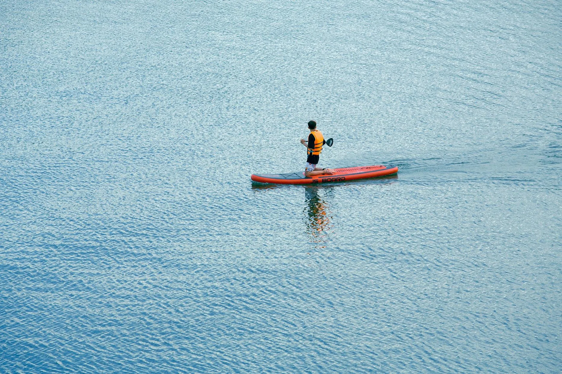 SUP paddler wearing safety gear and buoyancy aid