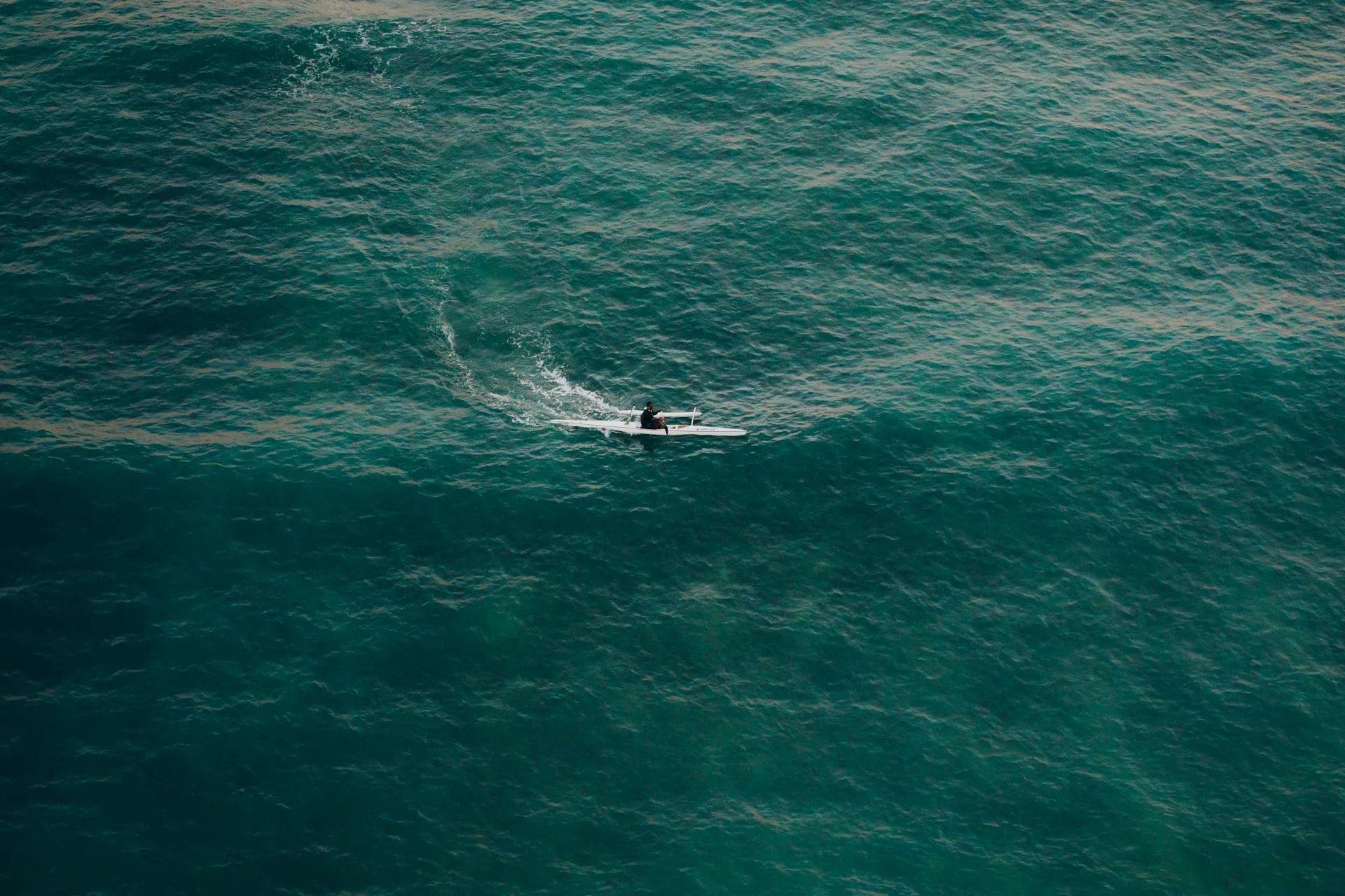 Solo kayaker navigating open ocean waters suited to a V-shaped hull kayak
