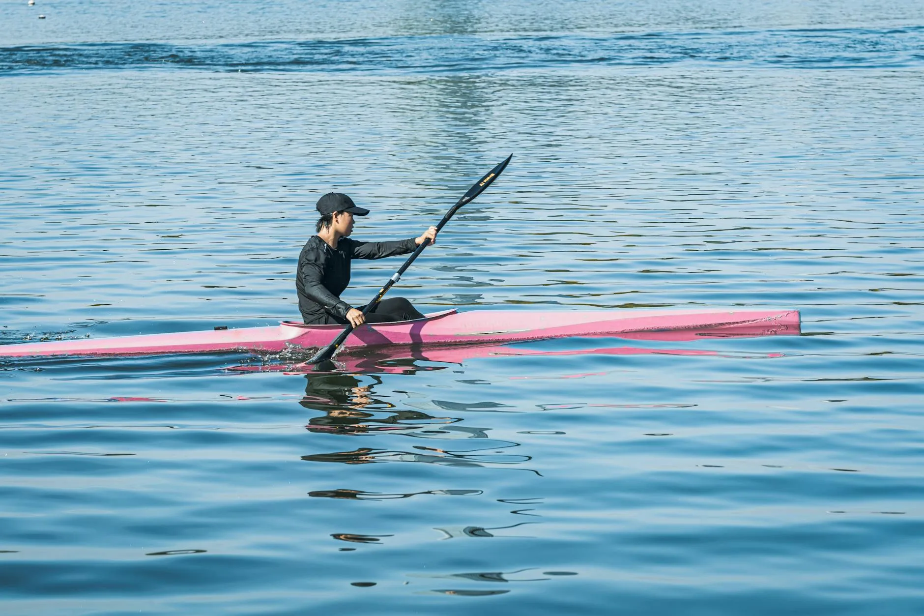Kayaker paddling a sprint kayak on calm water