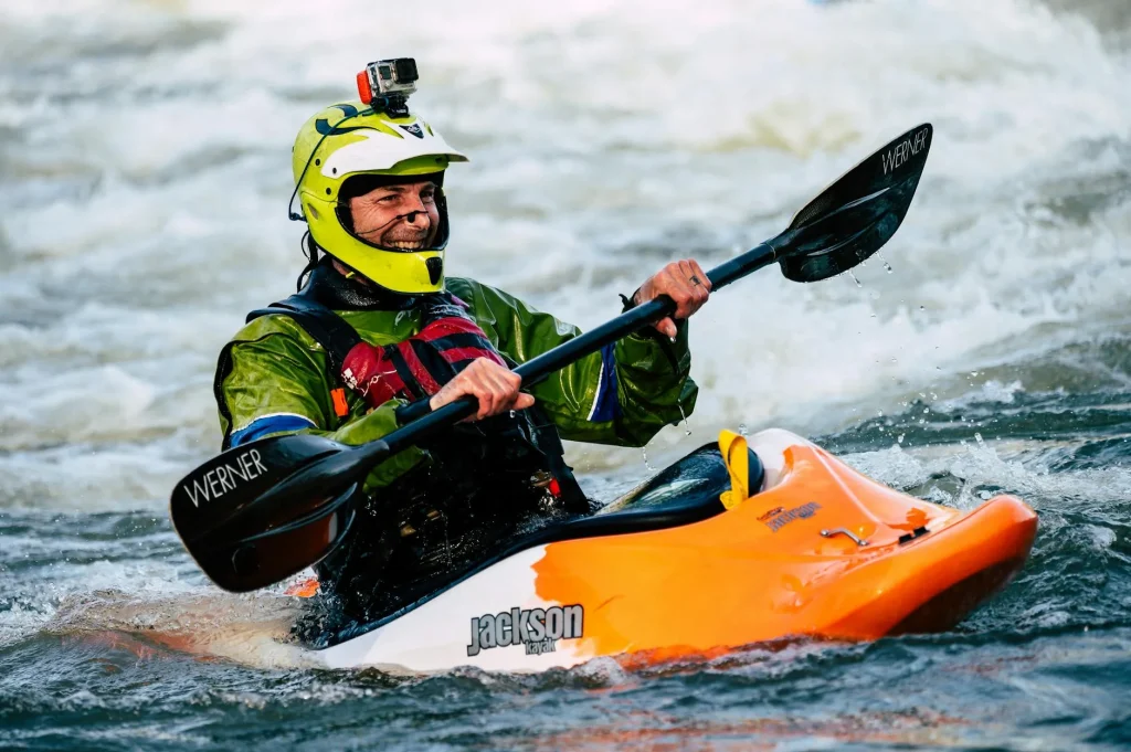 Kayaker paddling through whitewater rapids on a river