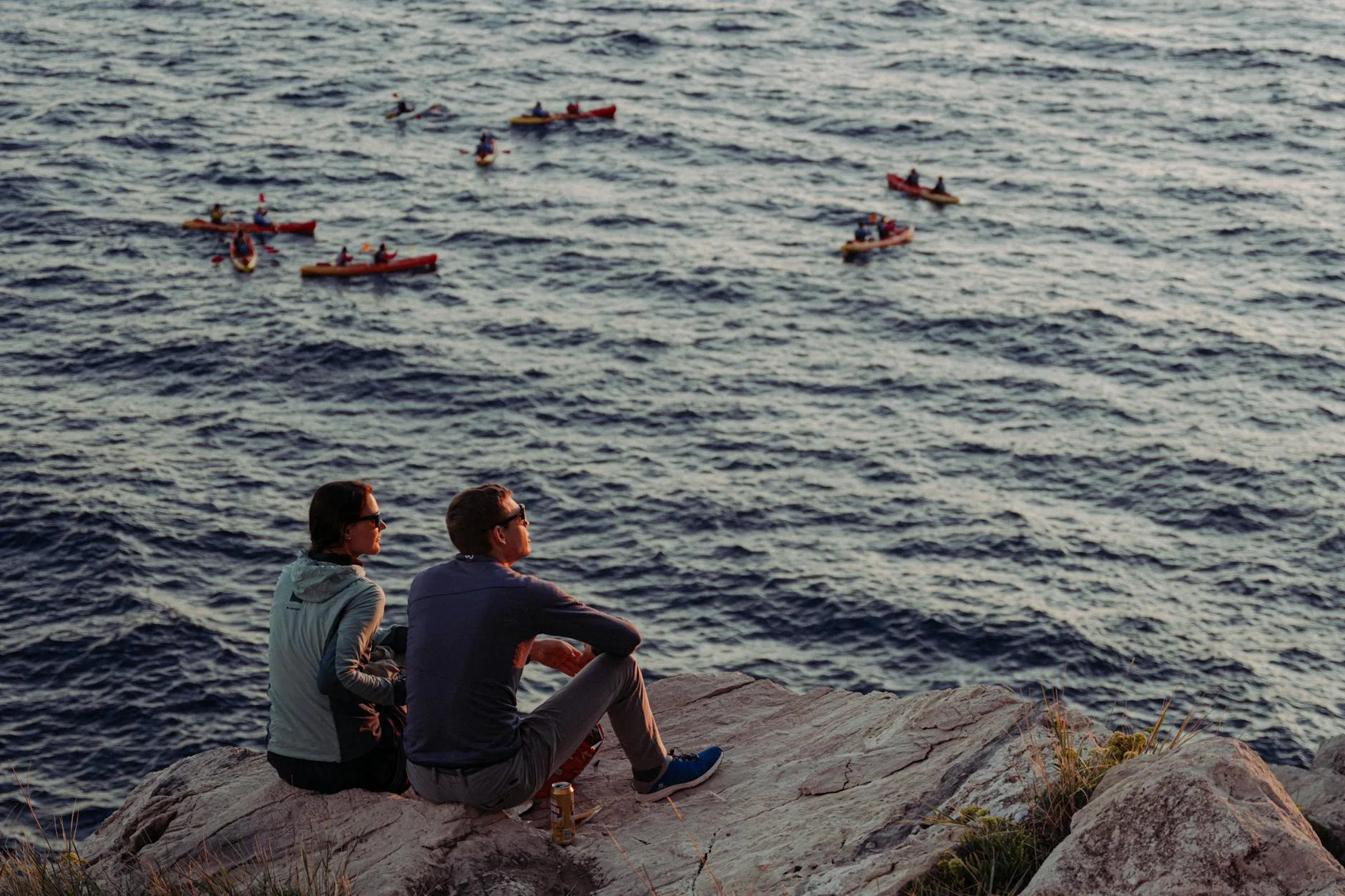 Sea kayakers paddling along dramatic coastal cliffs