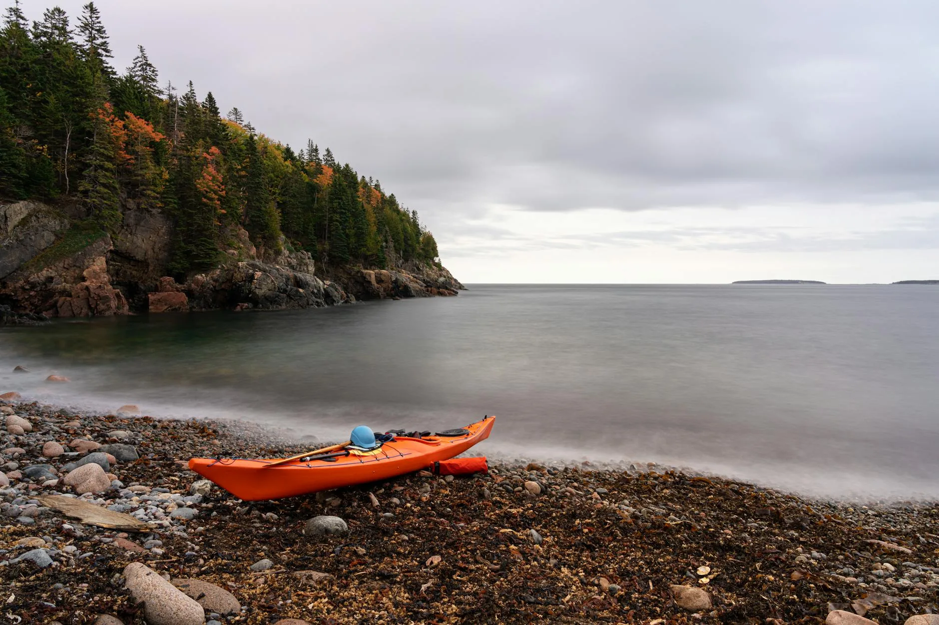 Kayak beached on shore with paddle resting