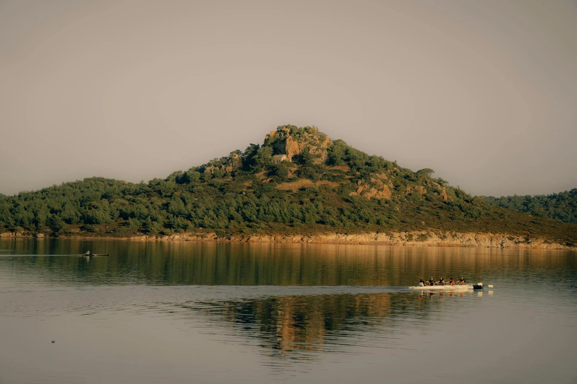 Kayak on a calm lake with mountain reflections at sunrise