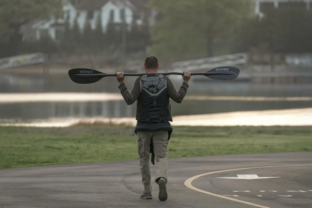 Kayak paddle blade cutting through water during forward stroke