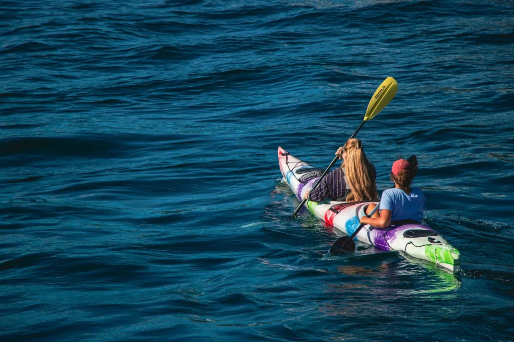 Kayak paddle cutting through calm lake water