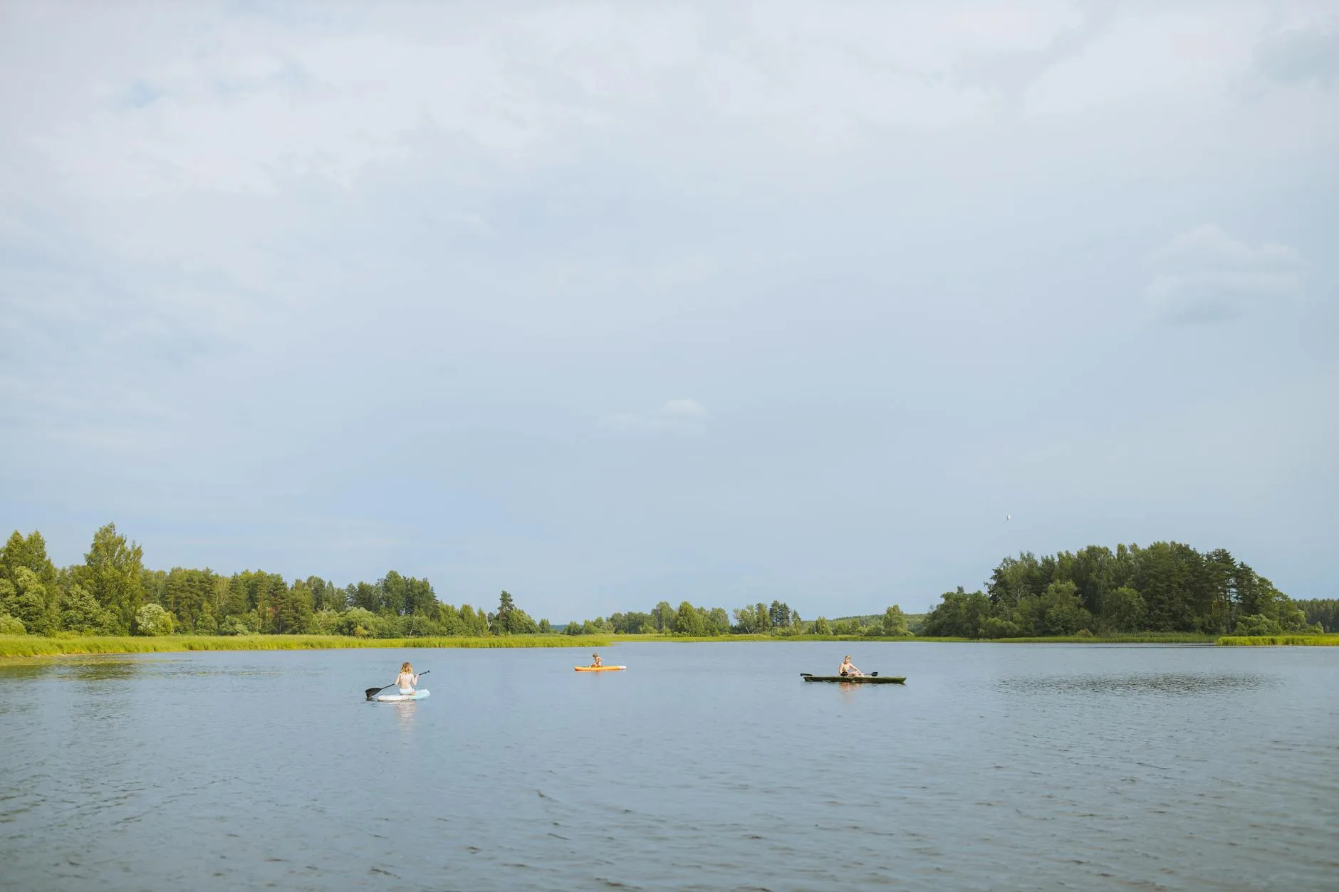 Kayaker touring a calm river with scenic surroundings
