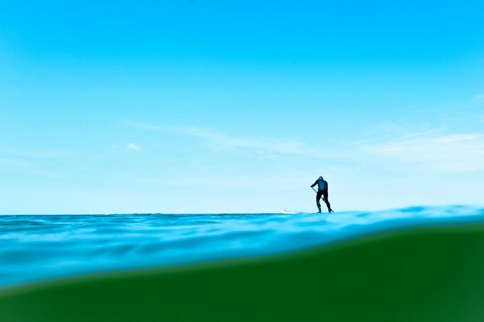 Paddleboard rider surfing on ocean waves