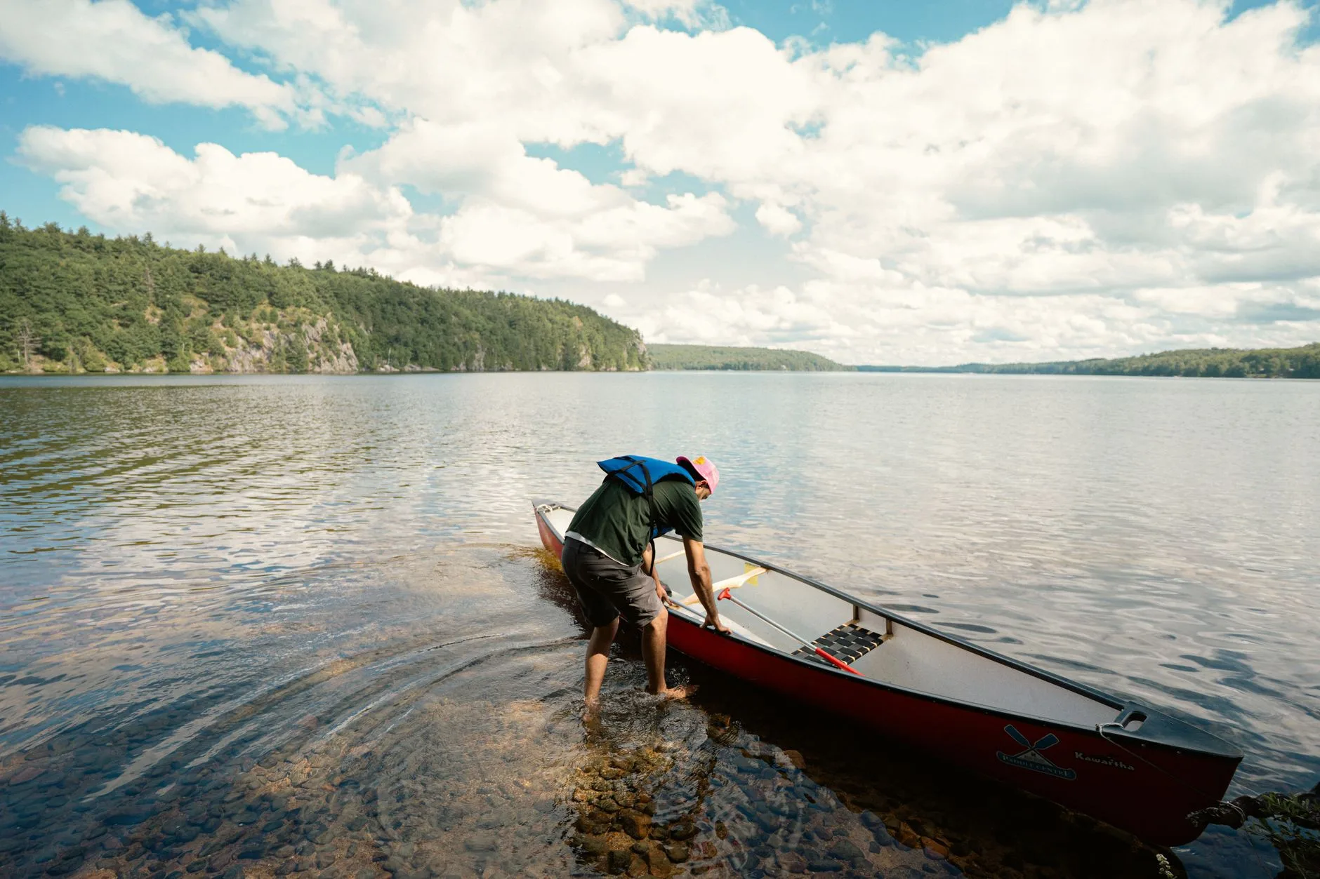 Kayaker checking safety equipment beside the water