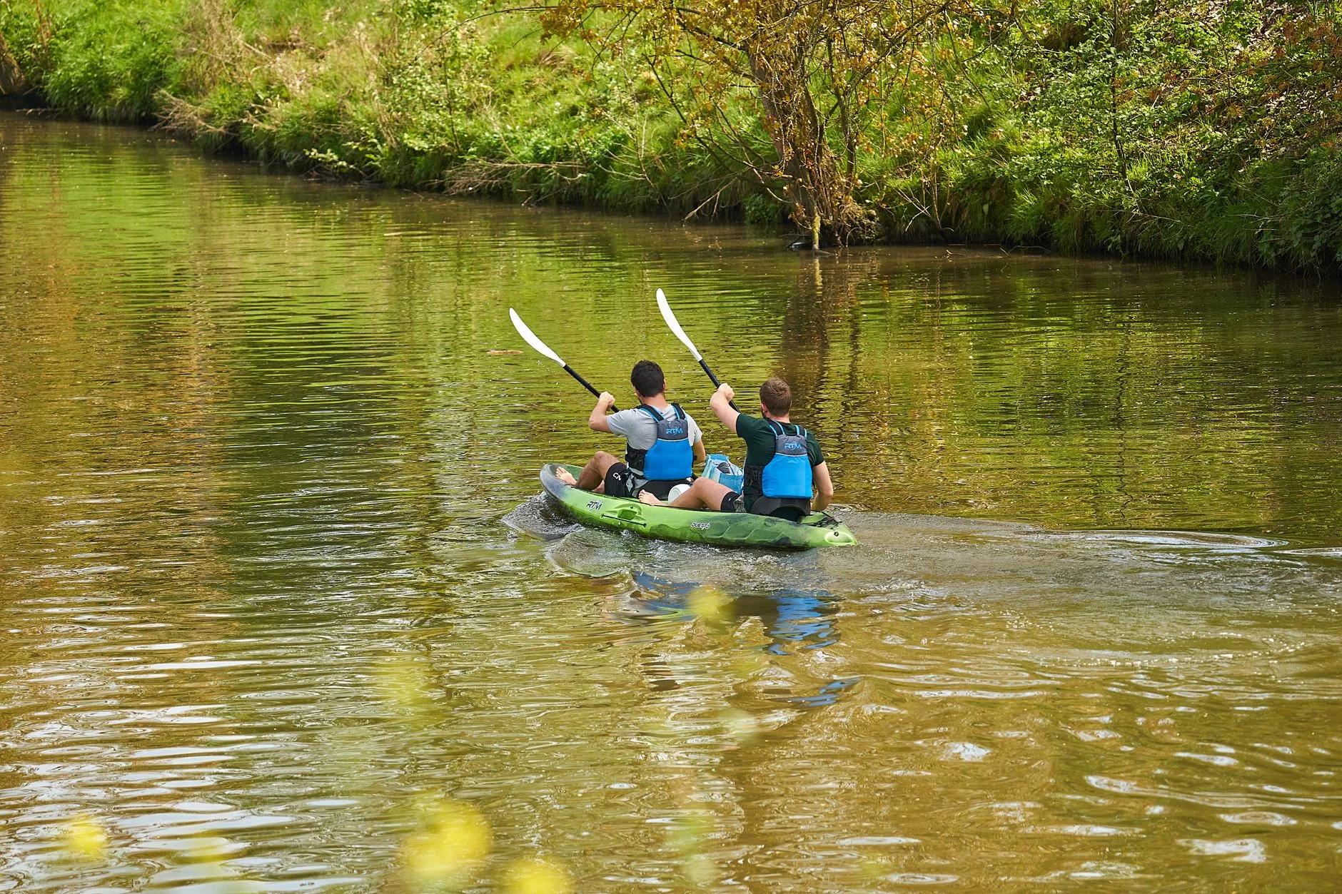 Kayak paddlers using an angle to cross gentle river current