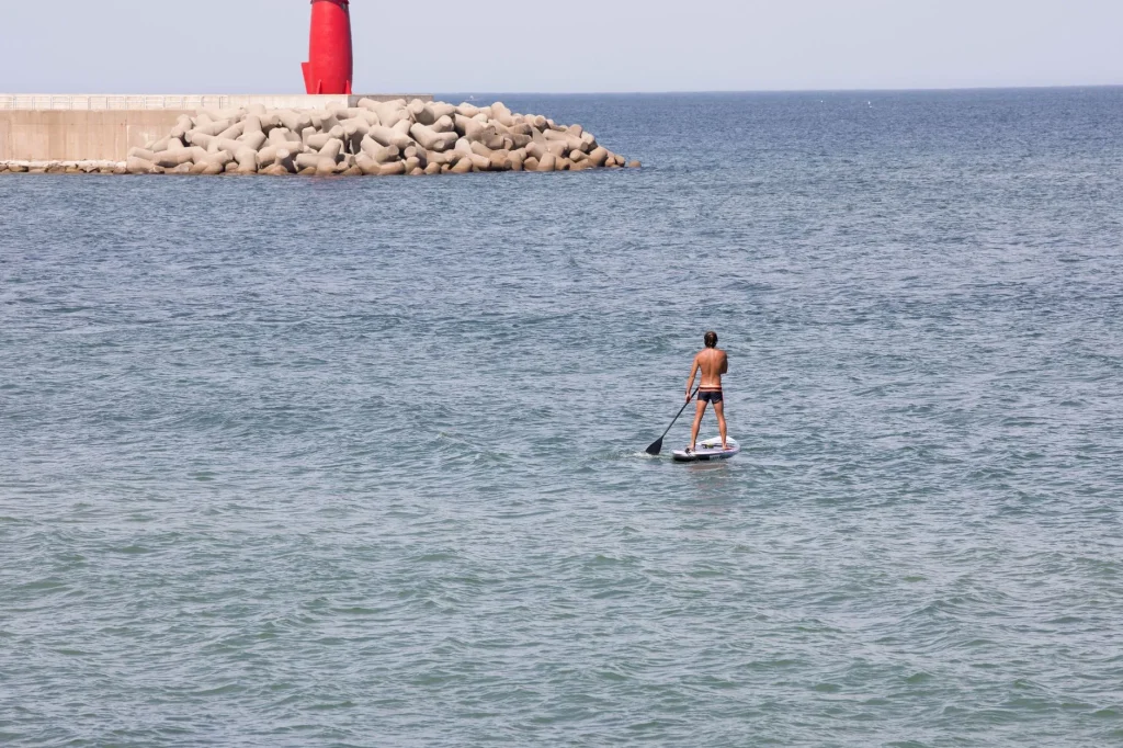 Paddleboarder on coastal water comparing river and sea paddling