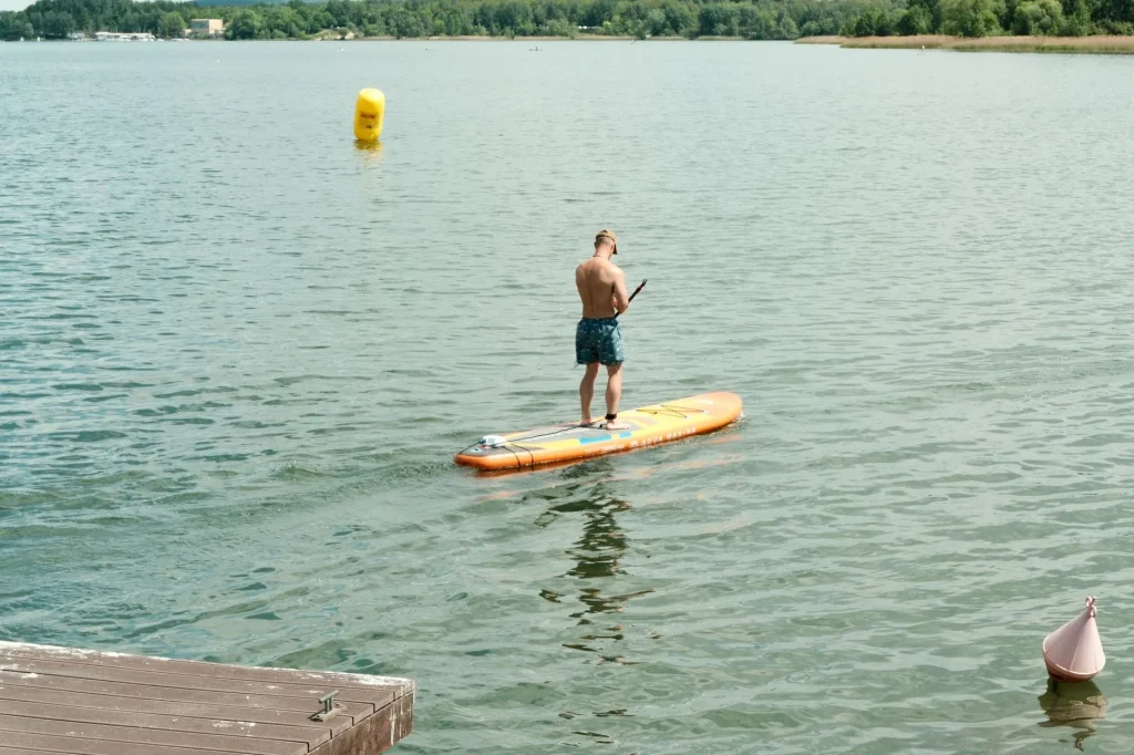 Paddleboarder turning a SUP on calm water