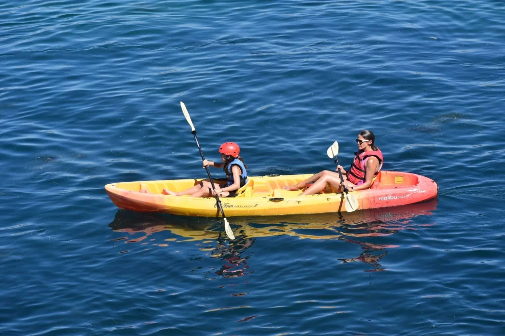 Child using a lightweight junior kayak paddle on calm water